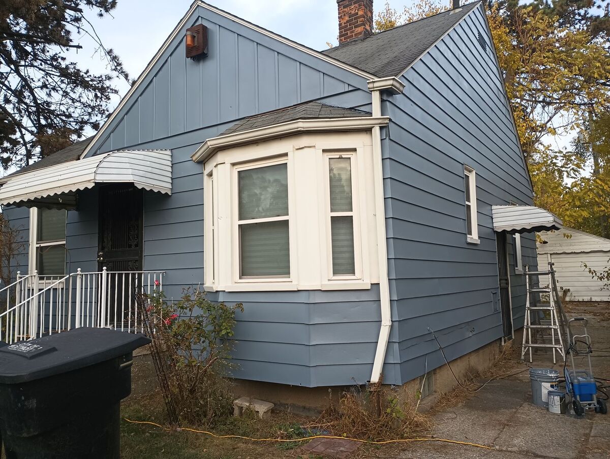 House exterior after repaint, fresh blue siding, front view