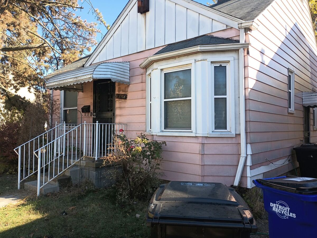Same house before repaint, faded pink siding, front view
