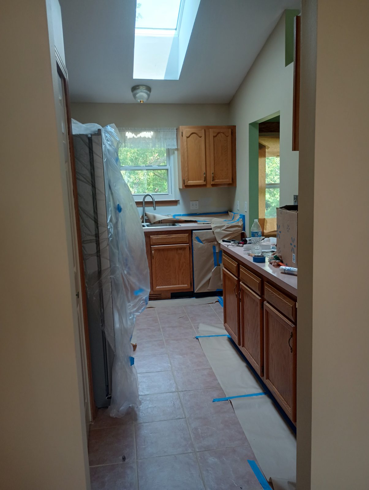 Kitchen before, honey oak cabinets masked off