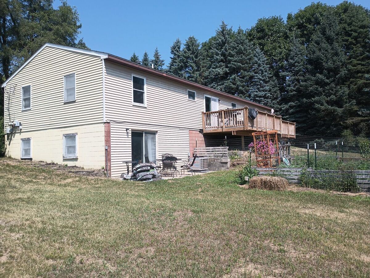 Same back patio and deck before repaint, yellow and pink siding