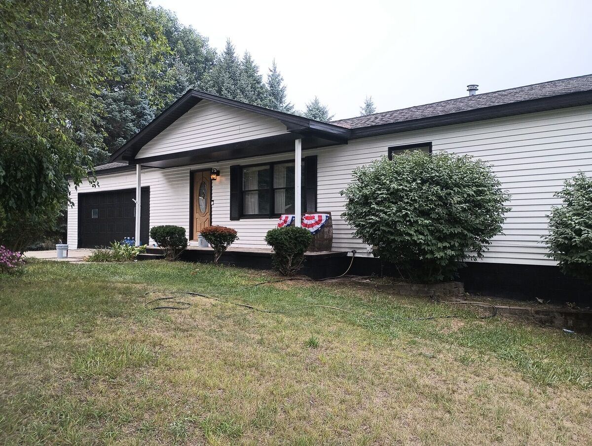 House front after repaint, crisp white siding with black trim and black roofline